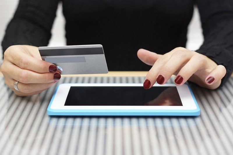 Frau benutzt eine Kreditkarte für Online Shopping