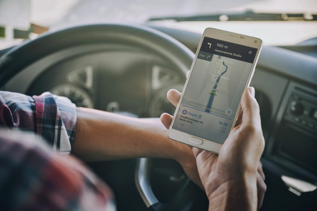 Jemand benutzt eine Routing App im Auto auf seinem Handy.