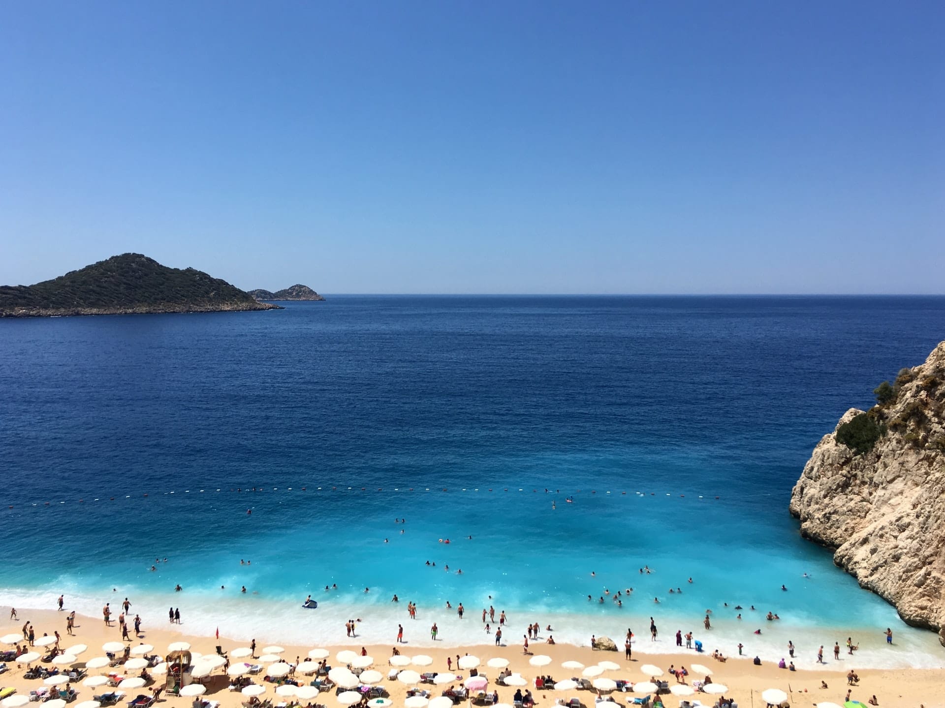 A busy beach in a tourist region symbolizes MBI's travel behavior and tourism data.