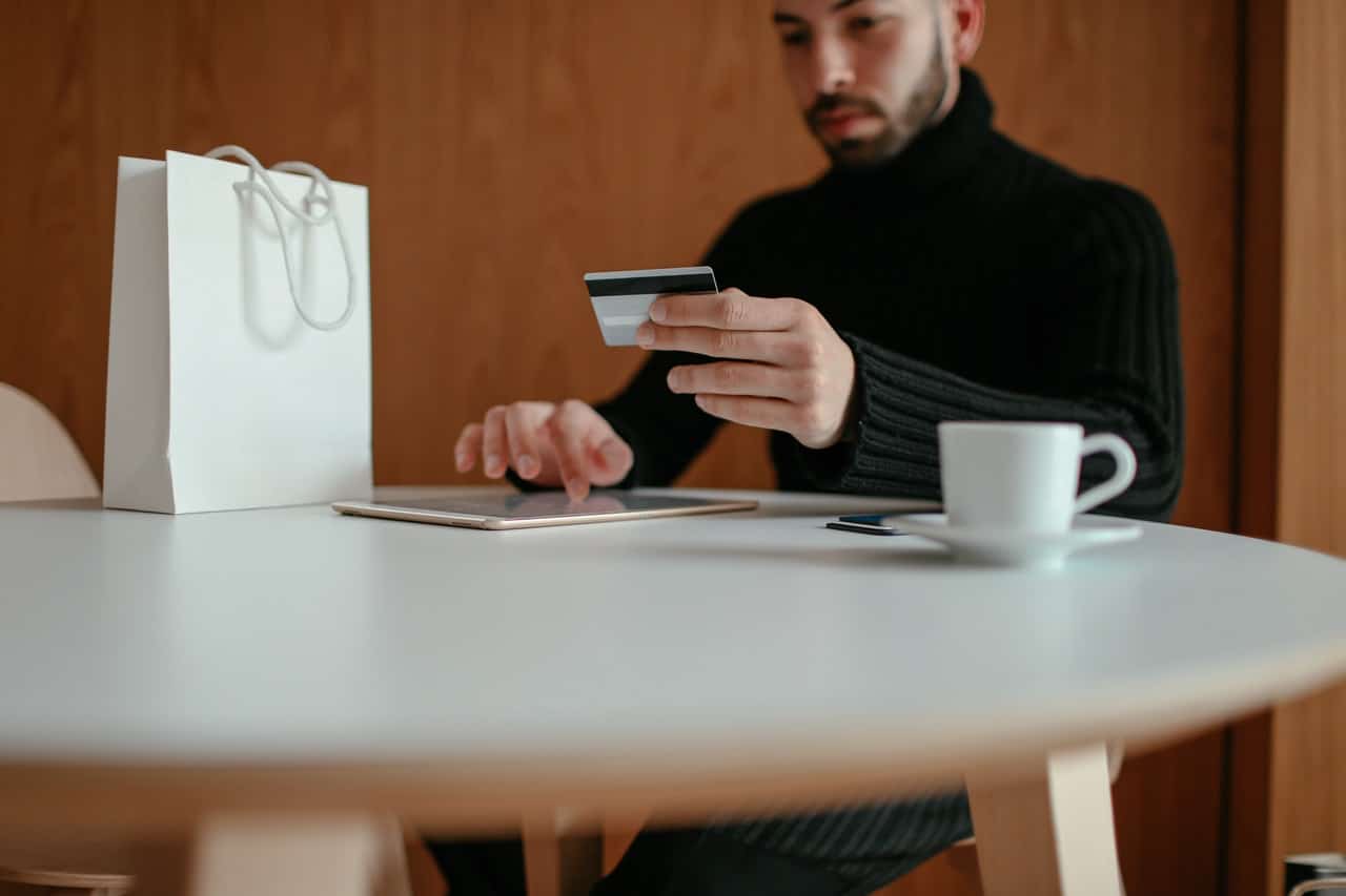 A man who has a high Online-Shopping Affinity uses the internet  on his tablet to buy something online.