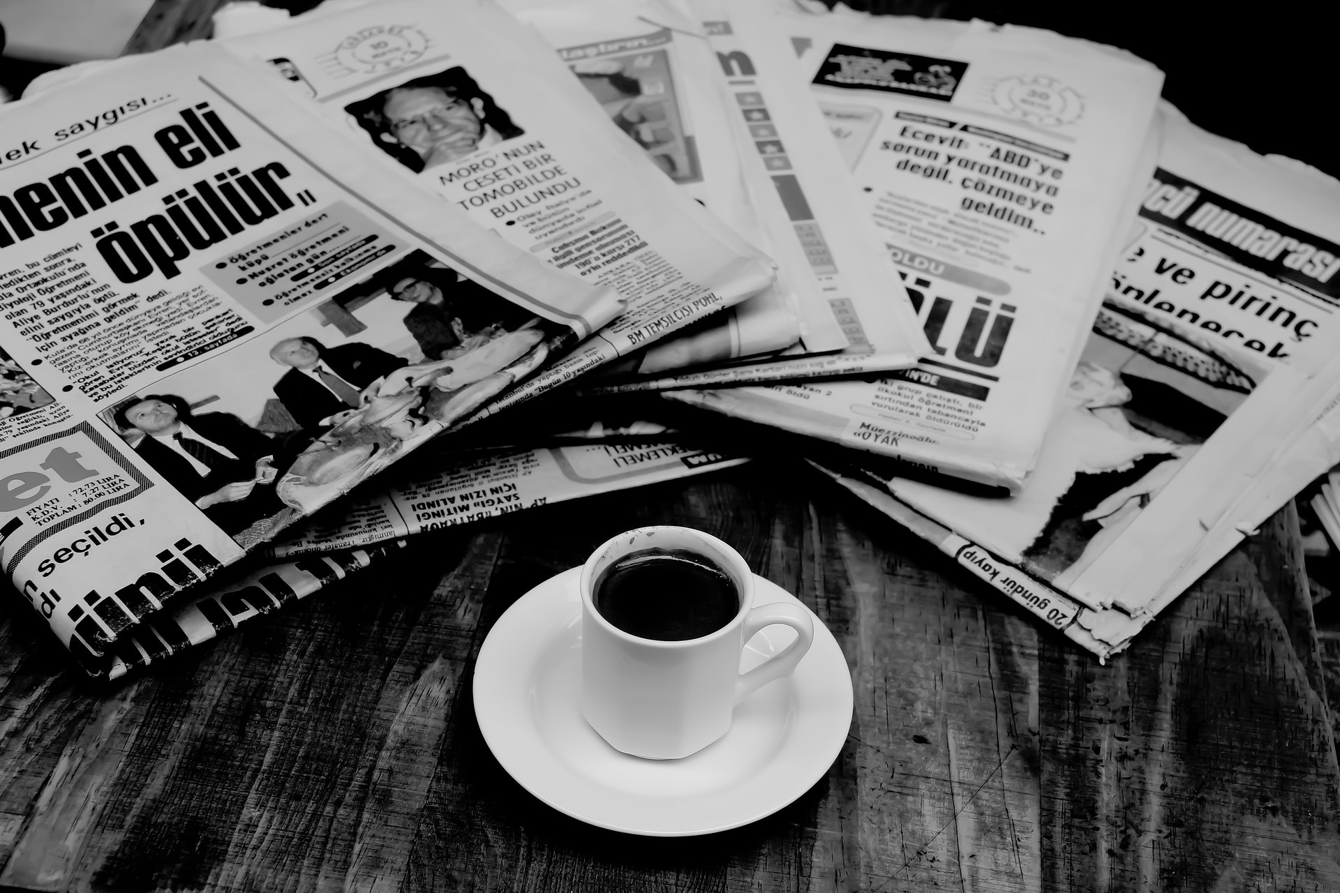 A stack of newspapers at the coffee table symbolizes the press articles about MBI that you will find on this page.