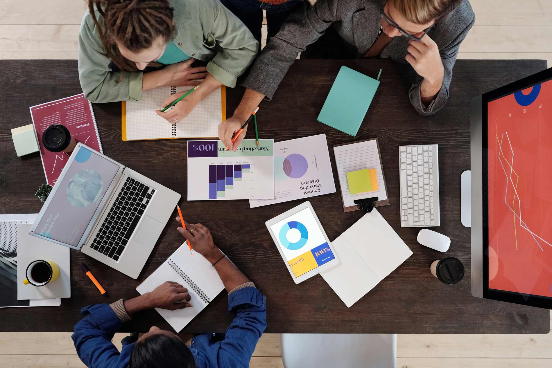 In einem Marktforschungsunternehmen betreiben Marktforscher zusammen an einem Tisch quantitative und qualitative Marktforschung.