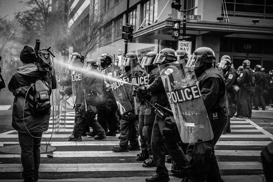 Polizisten mit Wasserwerfer in einem der vielen politischen Konflikte weltweit, die in den politischen internationalen Risikoindikator einfließen.