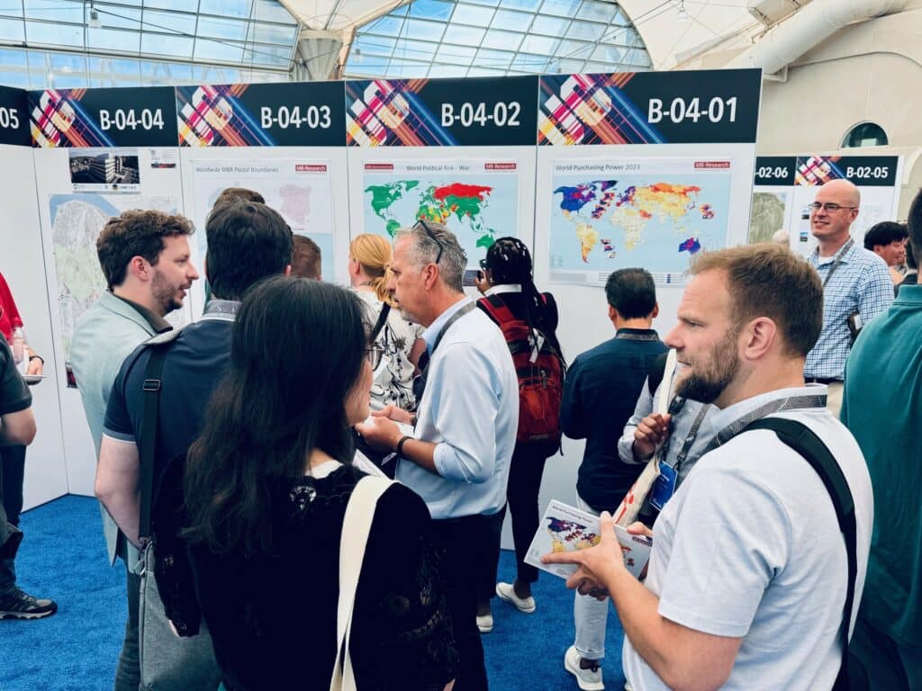Foto des MBI-Standes in der Map Gallery mit Karten zu den Internationalen Risikoindikatoren, Kaufkraft und Postleitzahlgrenzen auf der Esri UC 2024 in San Diego