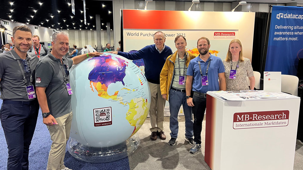 A picture of the MBI booth at the ESRI User Conference 2022. The booth will look similar again in 2023. Ray and Andreas are standing next to the globe on which our globally consistent and comparable geodata are shown.
