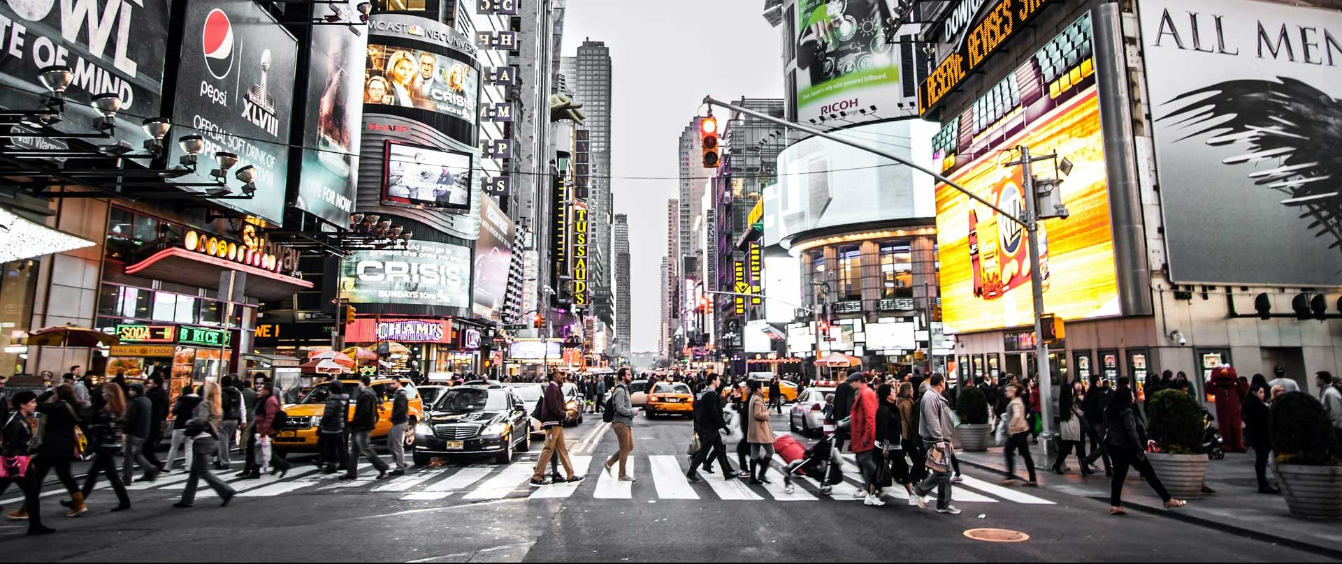 People of all ages and genders cross a street and symbolize the variety of MBI's sociodemographic data.