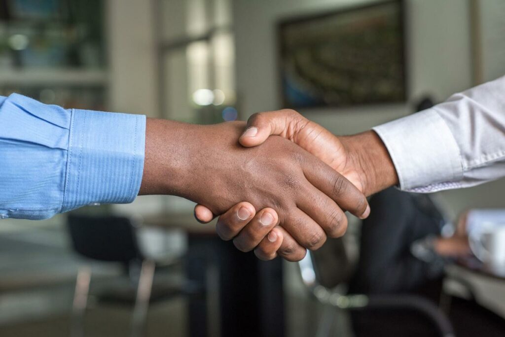 A handshake symbolizes the partnership between MBI and Nexiga.